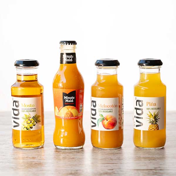 Botellas de zumo de mosto, melocotón y piña junto a Minute Maid