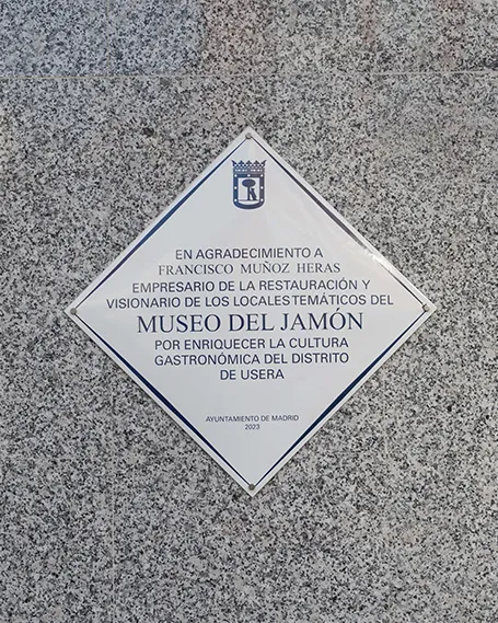 Placa de reconocimiento exterior en el Museo del Jamón en la Avenida Córdoba, Usera