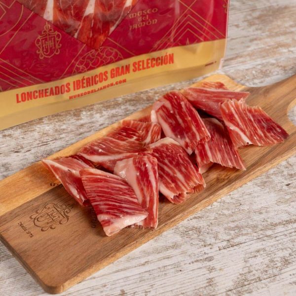 Sliced Iberian ham on a wooden board, Museo del Jamón.